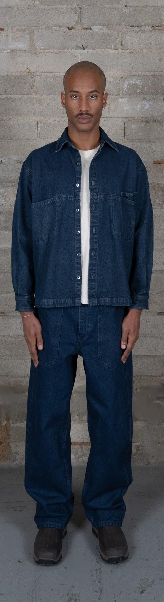A man wearing an indigo-dyed Olderbrother denim overshirt and matching wide-leg jeans