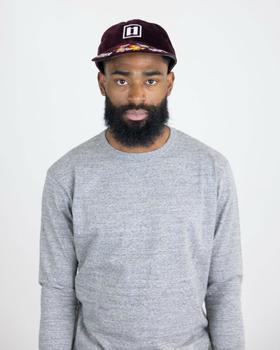 A man wearing a burgundy Papa Nui cap with a printed floral brim