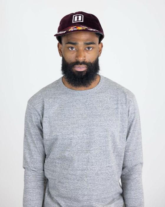 A man wearing a burgundy Papa Nui cap with a printed floral brim