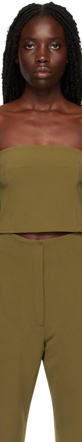A woman wearing an olive green Paris Georgia strapless tube top with matching high-waisted trousers