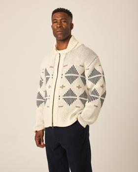 A man wearing a cream geometric-patterned Peregrine zip-through knitted cardigan