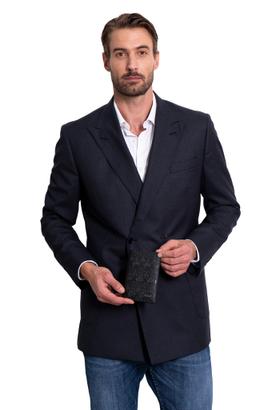 A man wearing a navy double-breasted blazer holding a black Pineda Covalin embossed sugar skull leather passport wallet