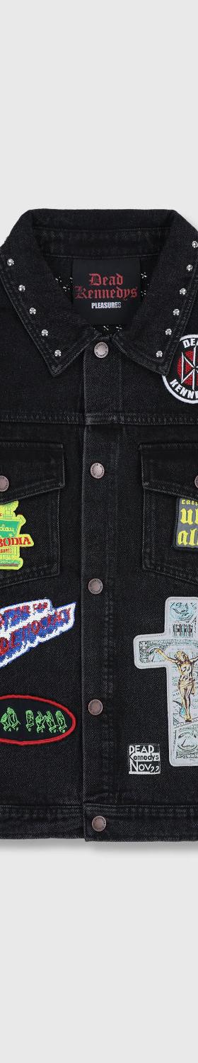 A black studded denim jacket with punk patches from PLEASURES