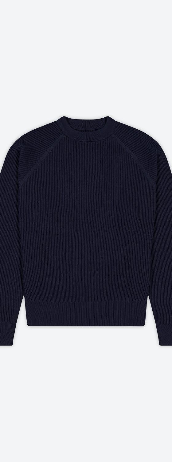 A navy ribbed raglan crewneck knit sweater on a plain background