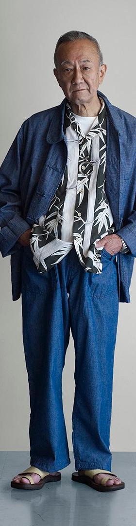 A man wearing an indigo POST O'ALLS chore jacket and matching denim trousers
