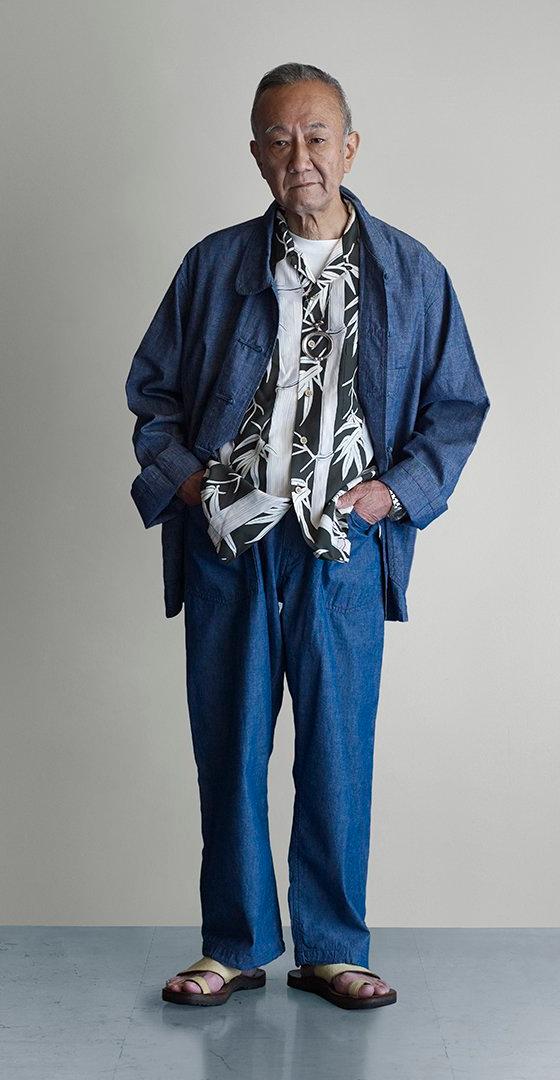 A man wearing an indigo POST O'ALLS chore jacket and matching denim trousers