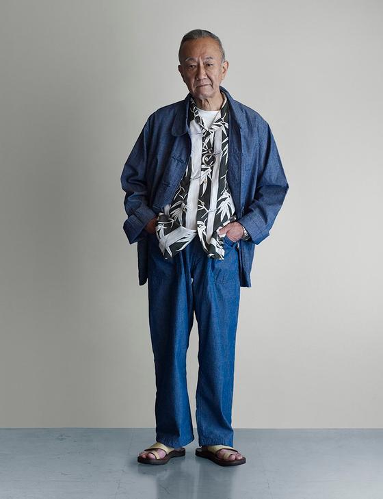 A man wearing an indigo POST O'ALLS chore jacket and matching denim trousers