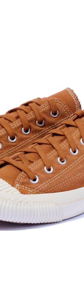 A pair of tan canvas PRAS sneakers with cream vulcanized soles