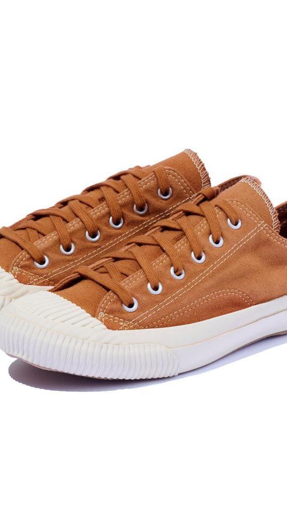 A pair of tan canvas PRAS sneakers with cream vulcanized soles