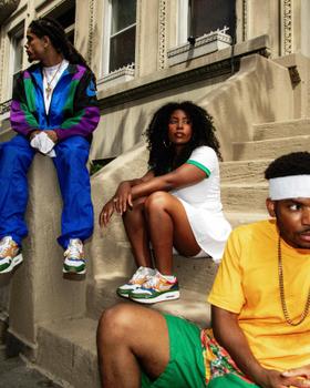 Three friends in colourful vintage sportswear and Nike Air Max sneakers hanging out on brownstone steps