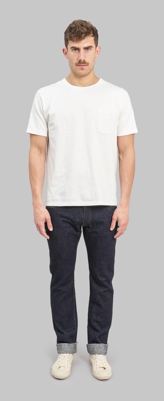 A man wearing a white pocket T-shirt with cuffed indigo Pure Blue Japan selvedge jeans