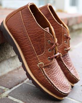 A pair of brown Rancourt & Co. pebbled leather moccasin chukka boots on brick steps