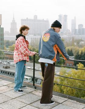 Two men wearing Rassvet jackets and wide trousers on a Moscow rooftop
