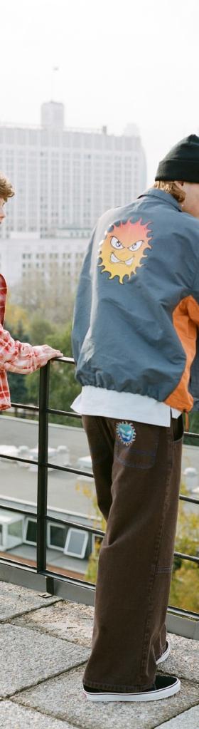 Two men wearing Rassvet jackets and wide trousers on a Moscow rooftop