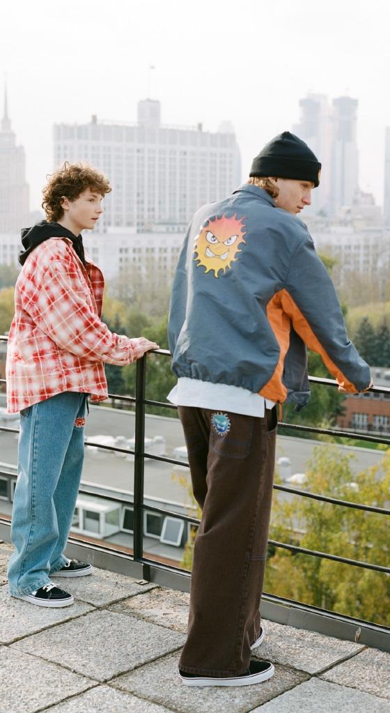 Two men wearing Rassvet jackets and wide trousers on a Moscow rooftop