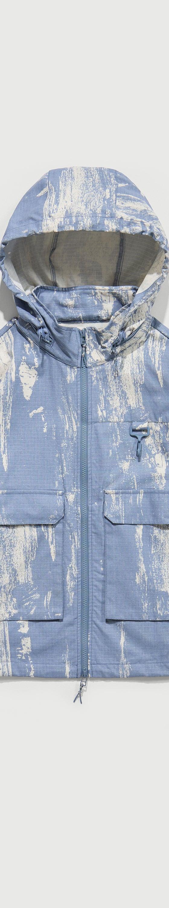 A light blue printed RCOS hooded technical shell jacket with utility chest pockets
