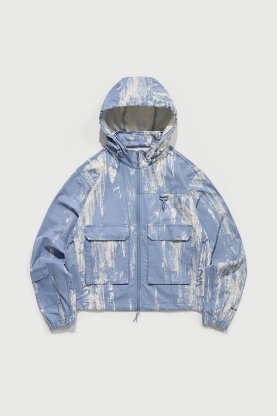 A light blue printed RCOS hooded technical shell jacket with utility chest pockets