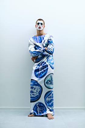 A man wearing a blue and white fossil-print satin Ricardo Andrez maxi dress