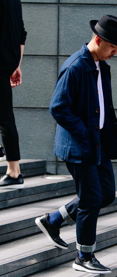 Two men walking down city steps in navy workwear and dark leather sneakers