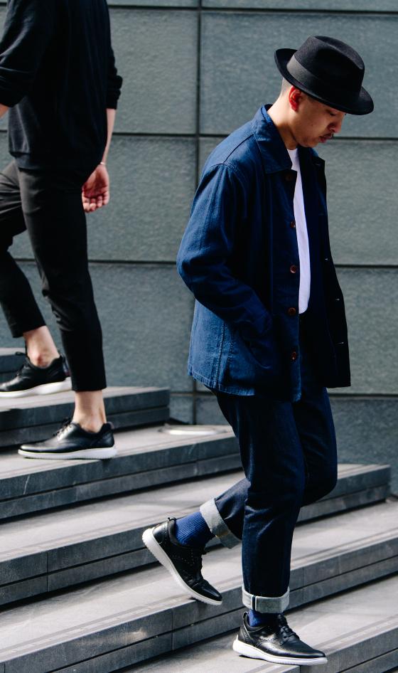 Two men walking down city steps in navy workwear and dark leather sneakers