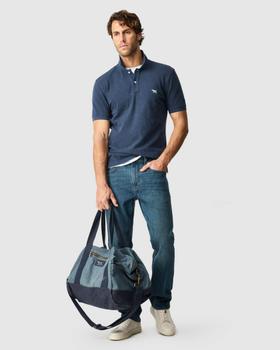 A man wearing an Adriatic-blue Rodd & Gunn Gunn sports-fit polo and jeans