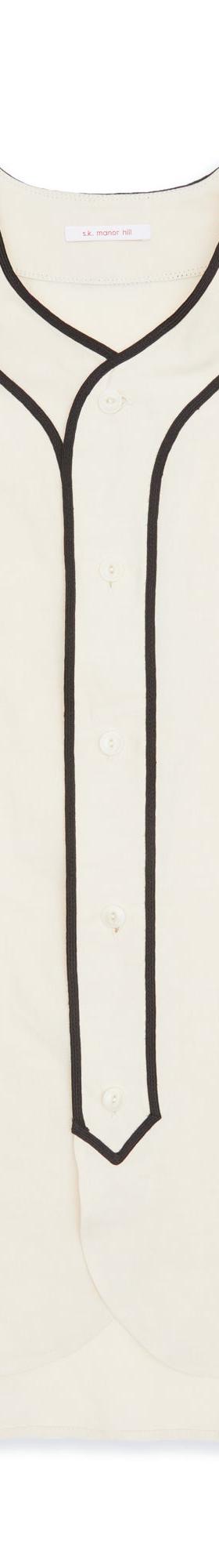 A cream s.k. manor hill baseball shirt with black piping on a plain background