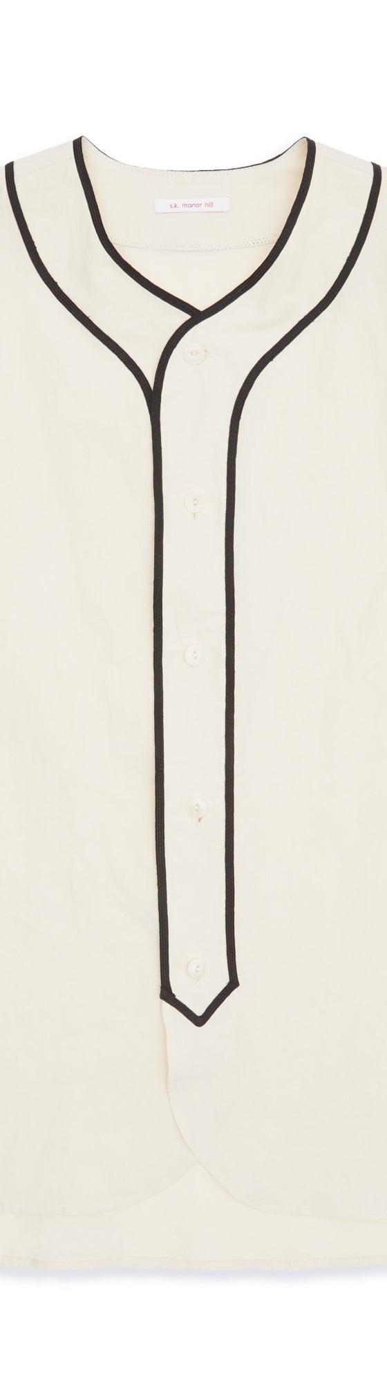 A cream s.k. manor hill baseball shirt with black piping on a plain background