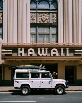Salvage Public Land Rover with surfboards outside the Hawaii Theatre