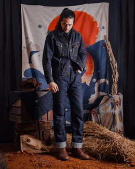 A man wearing a Samurai Jeans indigo denim jacket and matching selvedge jeans with brown leather boots
