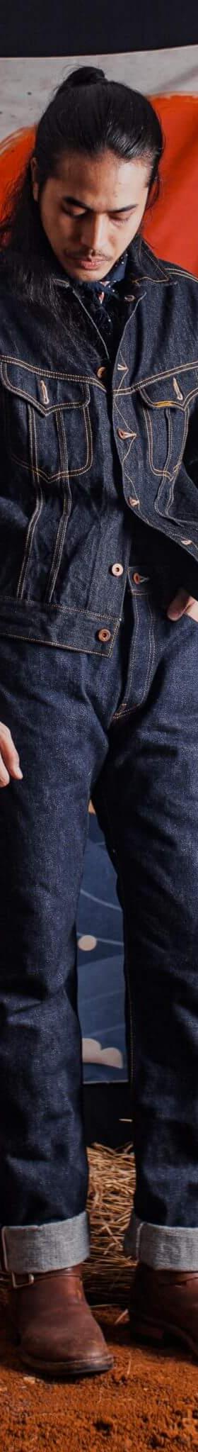 A man wearing a Samurai Jeans indigo denim jacket and matching selvedge jeans with brown leather boots