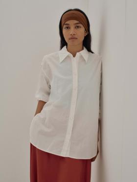 A woman wearing a white SAYAKA DAVIS cotton shirt with a rust-toned skirt