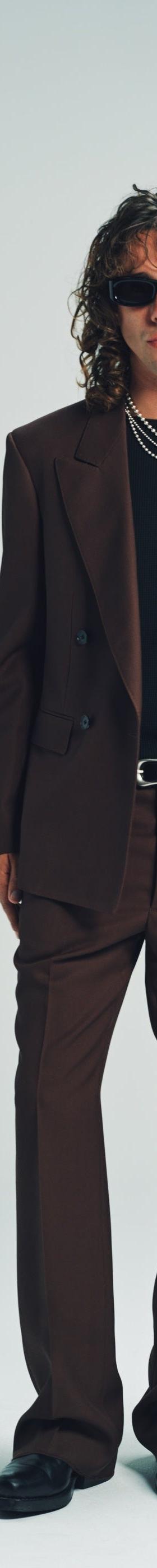 A man wearing a brown double-breasted Second/Layer suit with a black tee and sunglasses