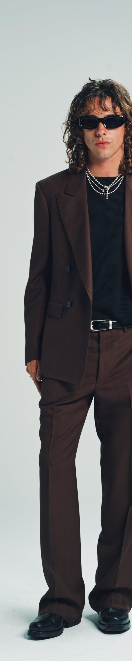A man wearing a brown double-breasted Second/Layer suit with a black tee and sunglasses