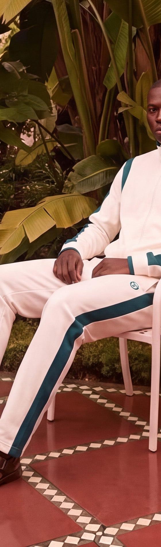 Sergio Tacchini model seated in a cream and green track suit