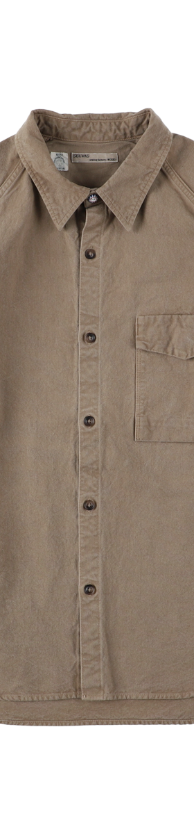 A tan naturally dyed SEUVAS canvas work shirt on a plain background
