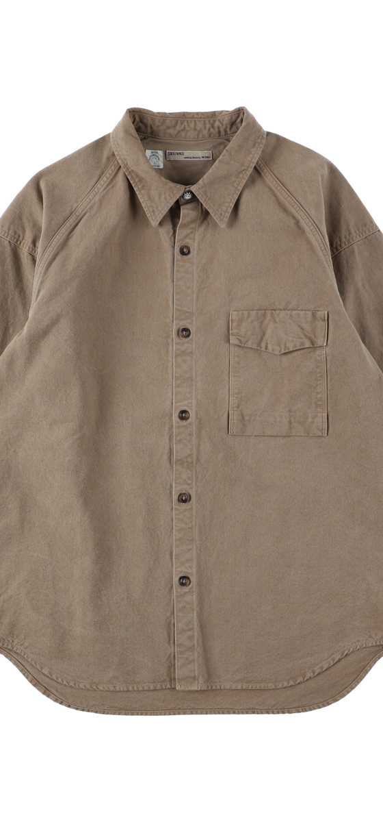 A tan naturally dyed SEUVAS canvas work shirt on a plain background