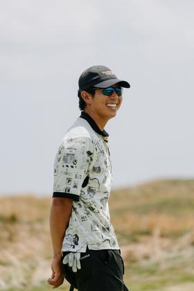 A man wearing Shinzo Tamura polarized sunglasses and a printed polo shirt outdoors
