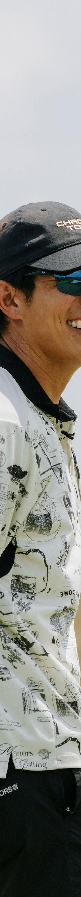 A man wearing Shinzo Tamura polarized sunglasses and a printed polo shirt outdoors