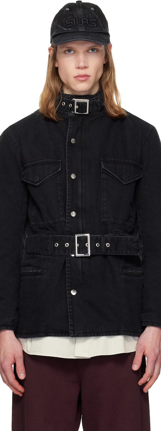 A man wearing a black belted denim jacket and cap by Silas