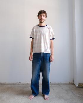 A man wearing a striped ringer t-shirt and faded wide-leg jeans by Small Talk Studio