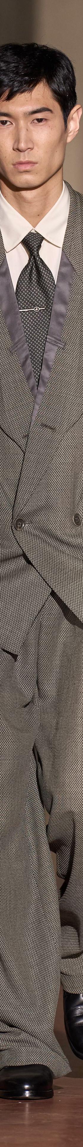 A man wearing a grey oversized double-breasted Soshiotsuki suit with wide pleated trousers