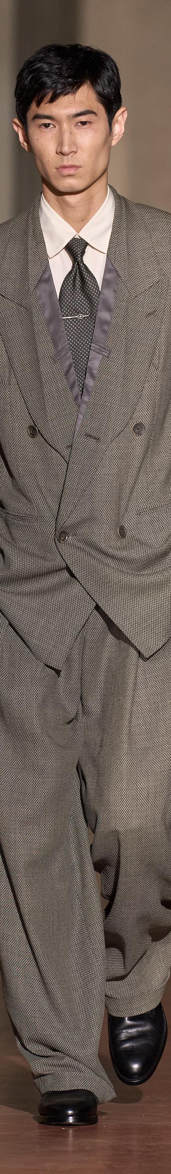 A man wearing a grey oversized double-breasted Soshiotsuki suit with wide pleated trousers