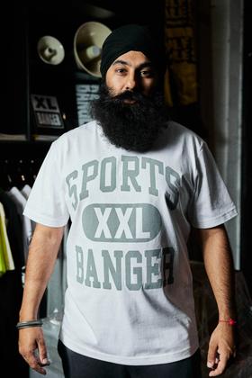 A man wearing a white Sports Banger XXL logo T-shirt