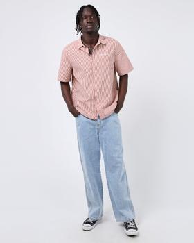 A man wearing a pink check St Goliath short-sleeve shirt with light-wash jeans