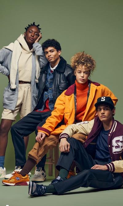Four models in Stadium Goods varsity jackets, hoodies and sneakers against a green backdrop