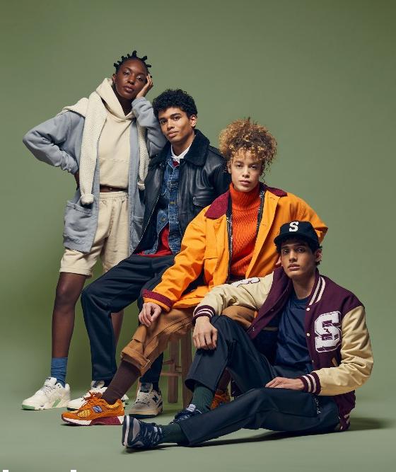 Four models in Stadium Goods varsity jackets, hoodies and sneakers against a green backdrop