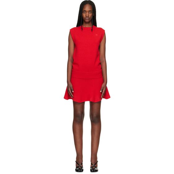 A woman wearing a red sleeveless Stefan Cooke knit top and flared mini skirt