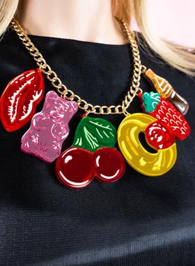 A woman wearing a Tatty Devine sweet-shop charm necklace with a black top