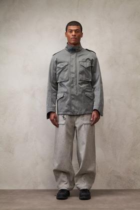 A man wearing a grey Ten C field jacket with grey wide-leg cargo trousers
