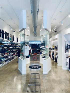 The interior of The Laboratory DTX sneaker shop, with sneakers and apparel displayed along bright white walls